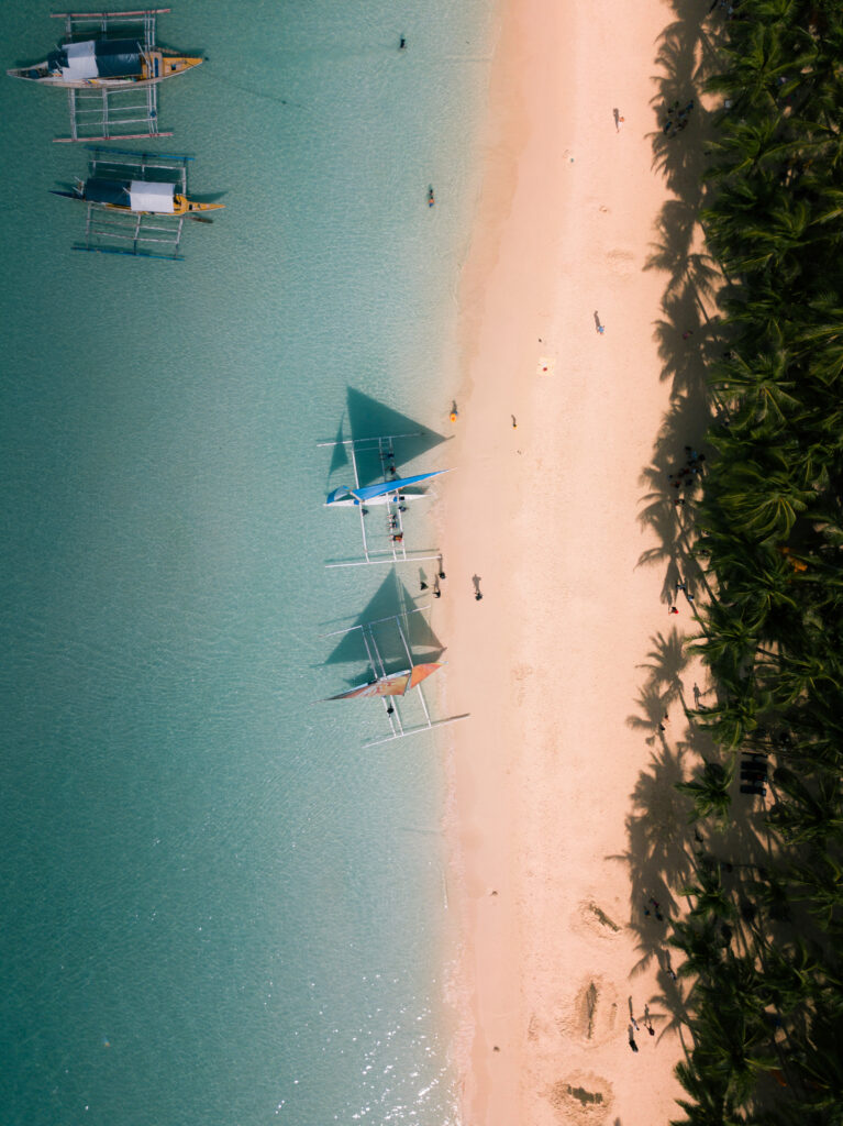 aerial shot of the boats on the calm crystal clear ocean